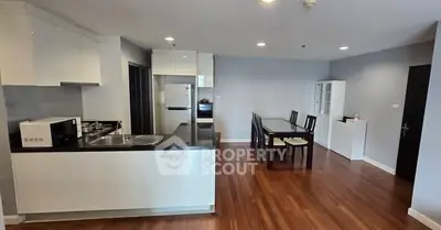 Modern kitchen and dining area with sleek design and wooden flooring.