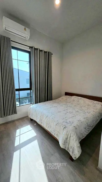 Cozy bedroom with natural light and modern air conditioning unit