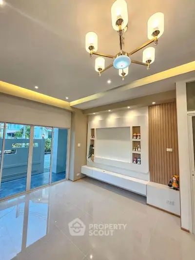Spacious modern living room with elegant lighting and balcony access, perfect for stylish urban living.