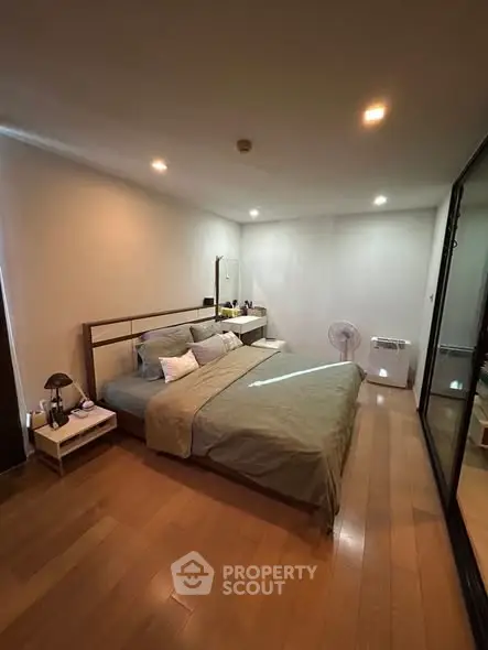 Spacious bedroom with modern decor and wooden flooring