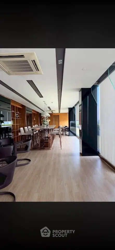 Spacious modern living room with floor-to-ceiling windows and elegant wooden flooring.