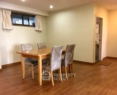 Spacious dining area with wooden table and chairs in modern apartment