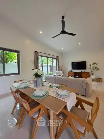 Spacious living room with elegant dining area and modern decor, perfect for family gatherings.