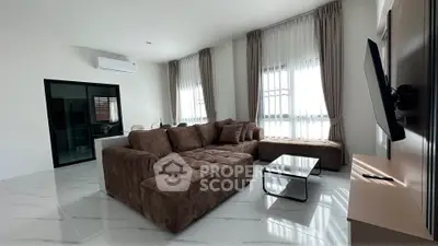 Spacious modern living room with plush brown sofa and large windows