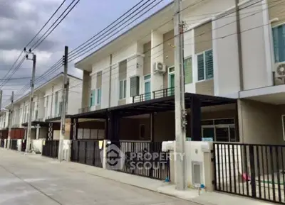 Modern townhouse exterior with gated parking in a suburban neighborhood.