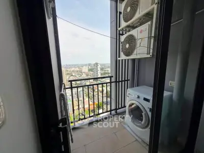 High-rise balcony with city view, featuring washing machine and air conditioning units.