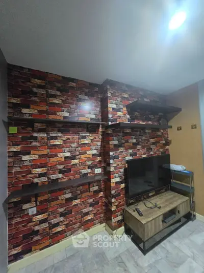 Stylish living room with brick accent wall and modern TV setup.
