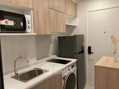 Modern compact kitchen with sleek appliances and wooden cabinetry