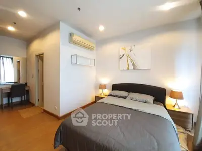 Modern bedroom with cozy bed, stylish decor, and natural lighting in a contemporary apartment.