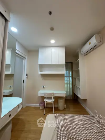 Modern bedroom with built-in desk and air conditioning, featuring sleek storage solutions and cozy ambiance.