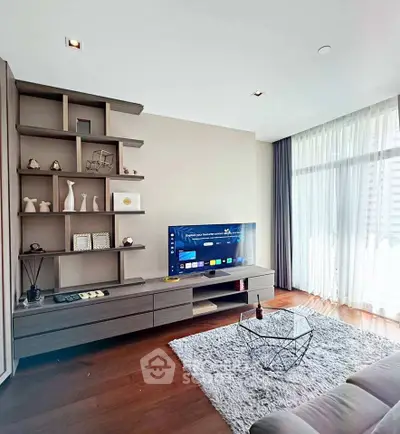 Modern living room with stylish shelving, large TV, and floor-to-ceiling windows for natural light.