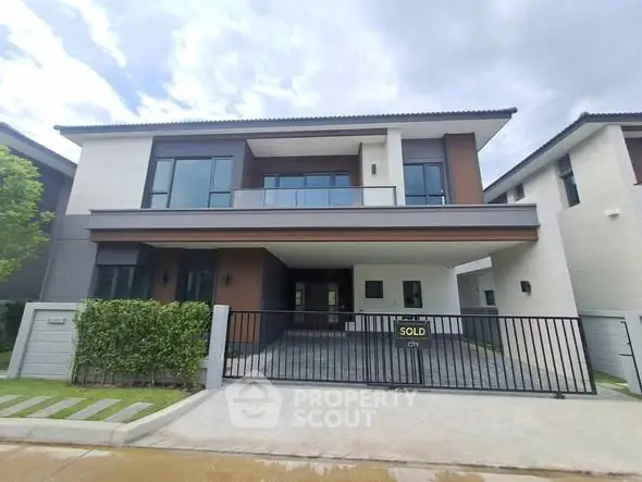Modern two-story house with sleek design and spacious driveway, perfect for family living.