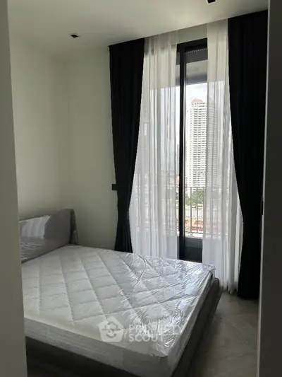 Modern bedroom with large window and city view, featuring a minimalist design and natural light.