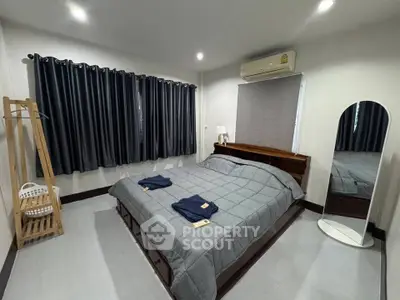 Spacious bedroom with modern decor and ample natural light, featuring a cozy bed and stylish furnishings.