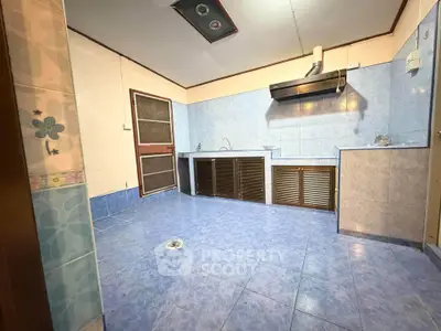 Spacious kitchen with blue tile flooring and modern ventilation system