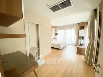 Spacious bedroom with modern furnishings and large windows for natural light.