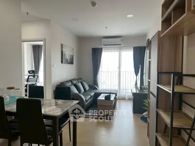 Modern living room with stylish furniture and natural light from large windows.