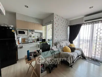 Cozy living room with kitchen open layout and balcony view, featuring modern appliances and stylish decor.