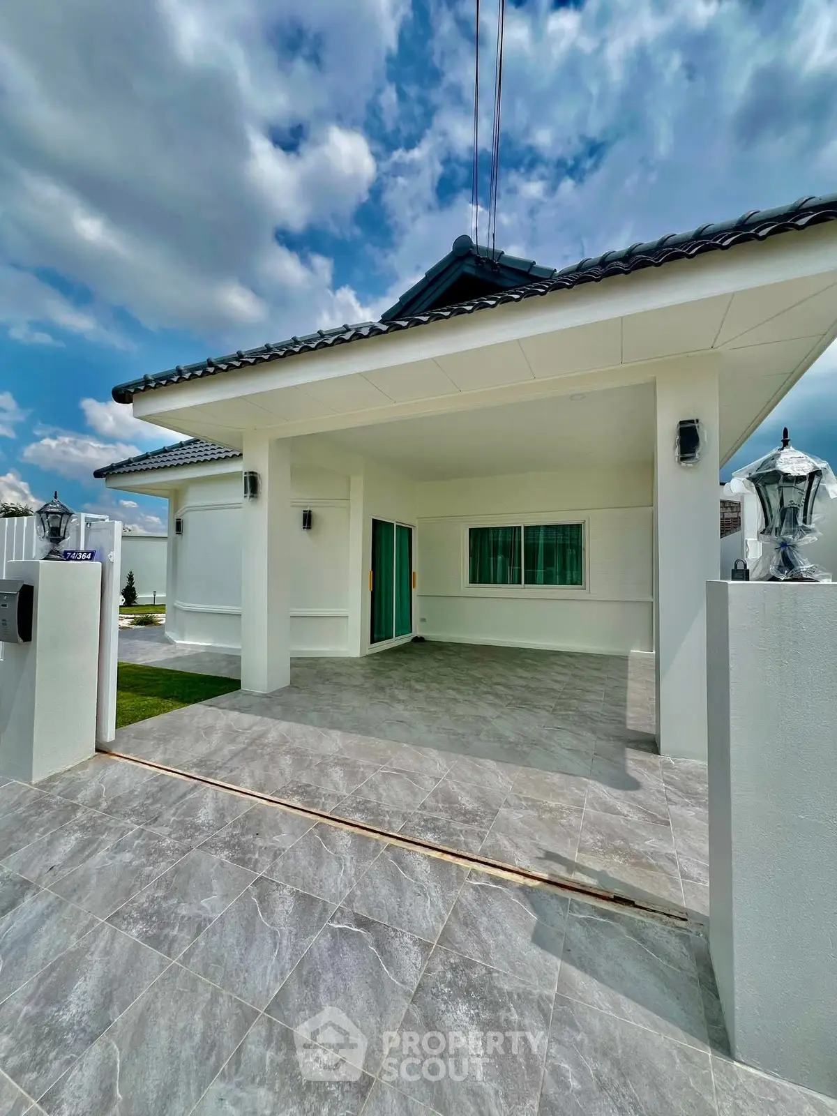 Modern single-story house with tiled driveway and sleek exterior design.