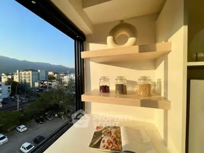 Bright kitchen nook with open shelves and scenic city view, perfect for modern living.