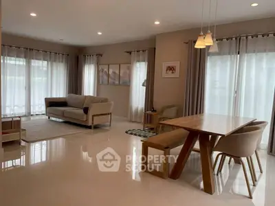 Spacious modern living room with elegant dining area and large windows.
