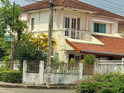 Charming two-story house with red-tiled roof and lush garden in a serene neighborhood.