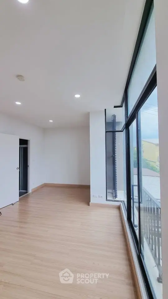 Spacious room with large windows and wooden flooring, perfect for natural light lovers.