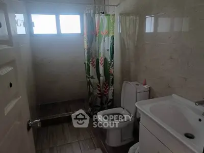 Cozy bathroom with tropical shower curtain and modern fixtures