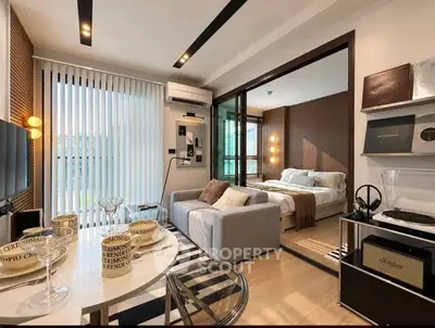 Modern open-plan living room with stylish decor and cozy bedroom in a chic apartment.