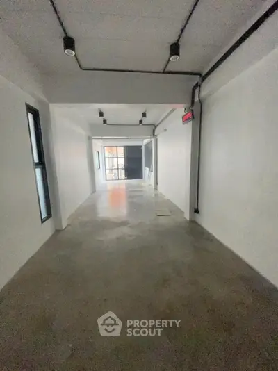 Spacious industrial-style hallway with concrete flooring and modern lighting
