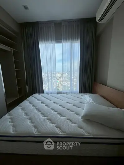 Spacious bedroom with large window offering stunning city views, featuring a comfortable bed and modern design.