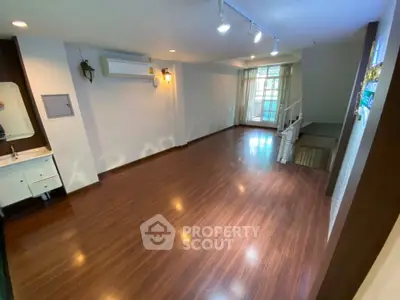 Spacious living room with wooden flooring and natural light