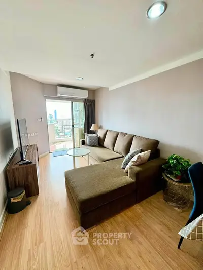 Spacious living room with modern decor and city view balcony access.