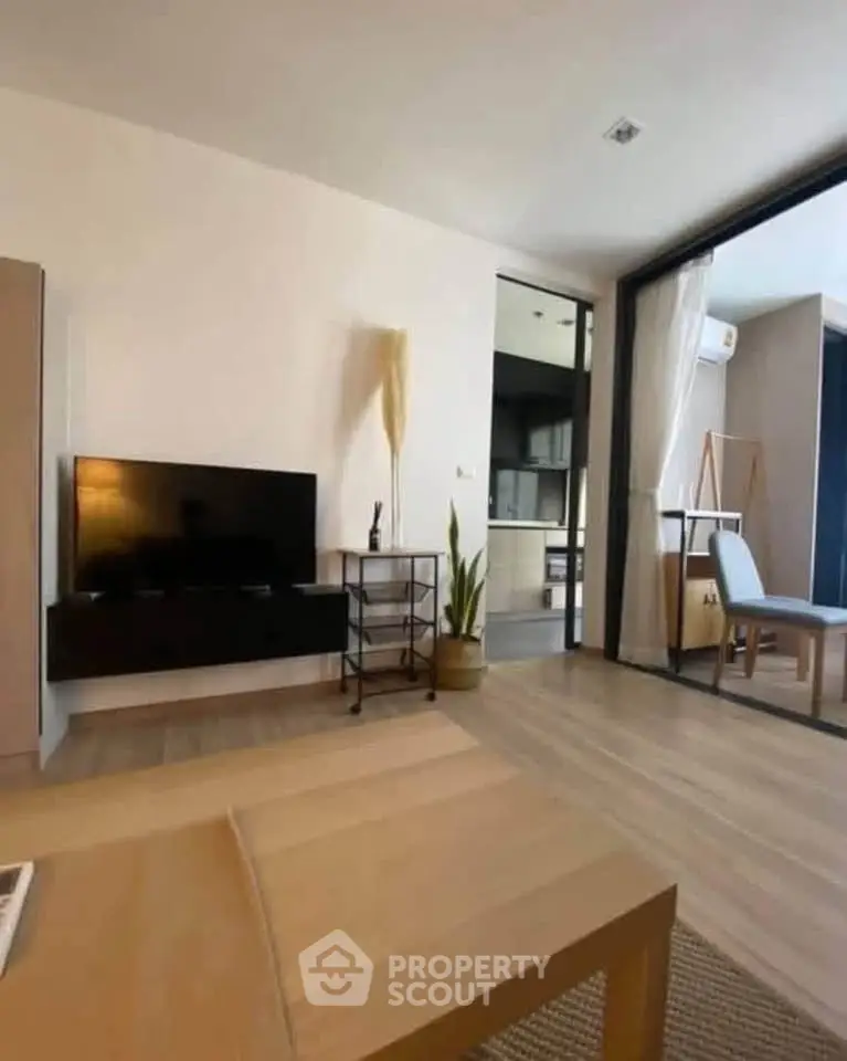 Modern living room with sleek TV setup and open layout, featuring stylish decor and natural light.