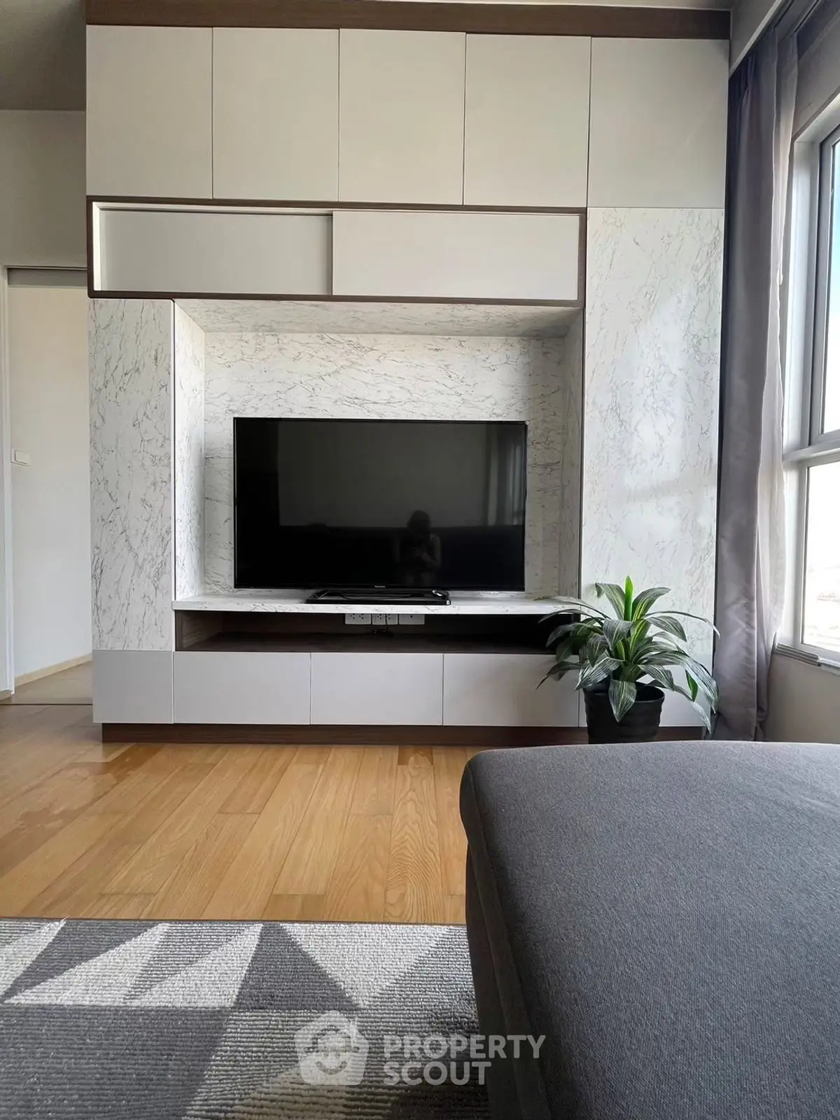 Modern living room with sleek TV unit and large window view