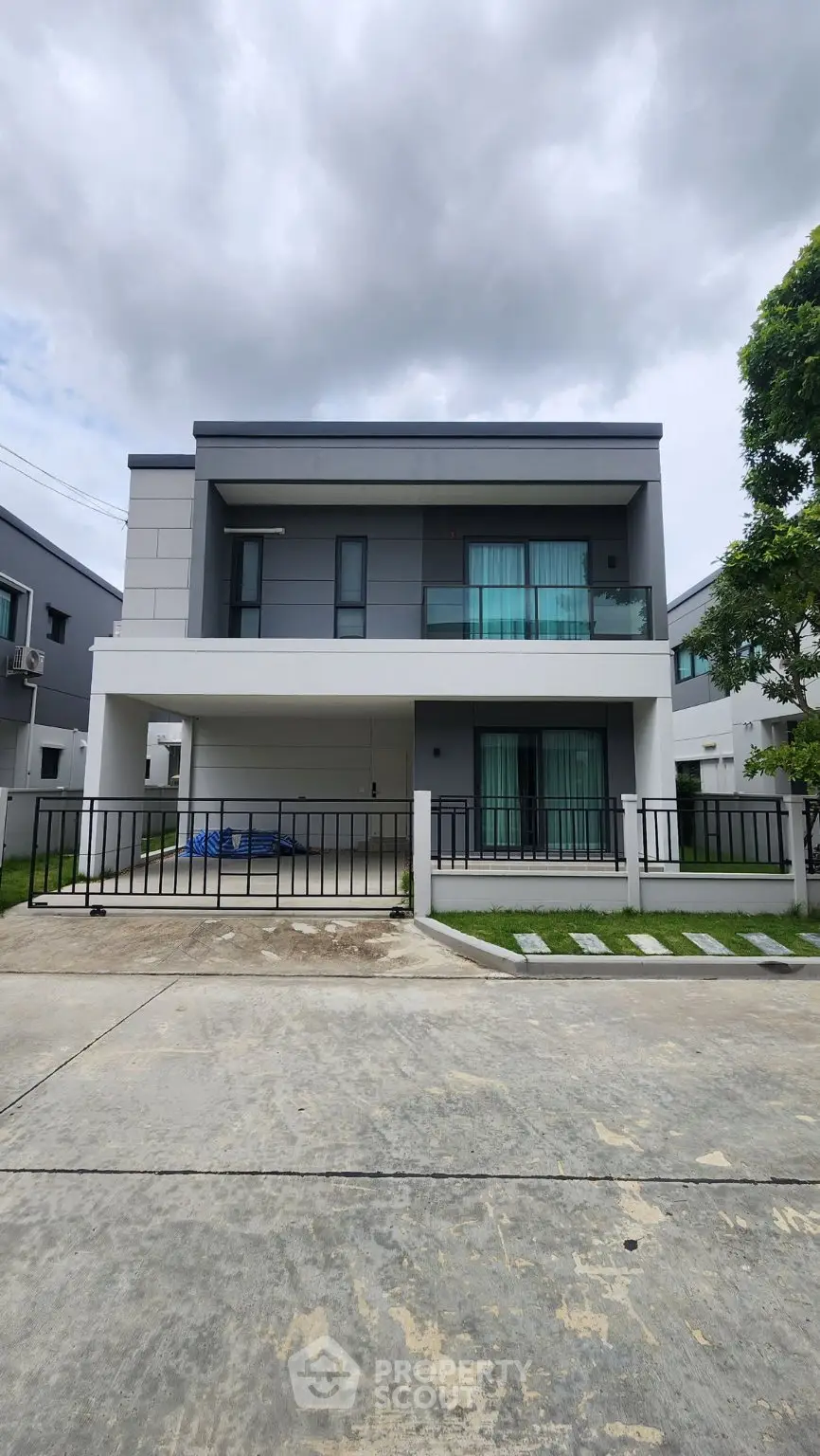 Modern two-story house with sleek design and spacious driveway in a serene neighborhood.