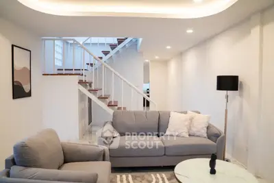 Spacious modern living room with stylish furniture and elegant staircase