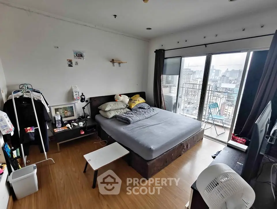 Spacious bedroom with city view and balcony access in modern apartment