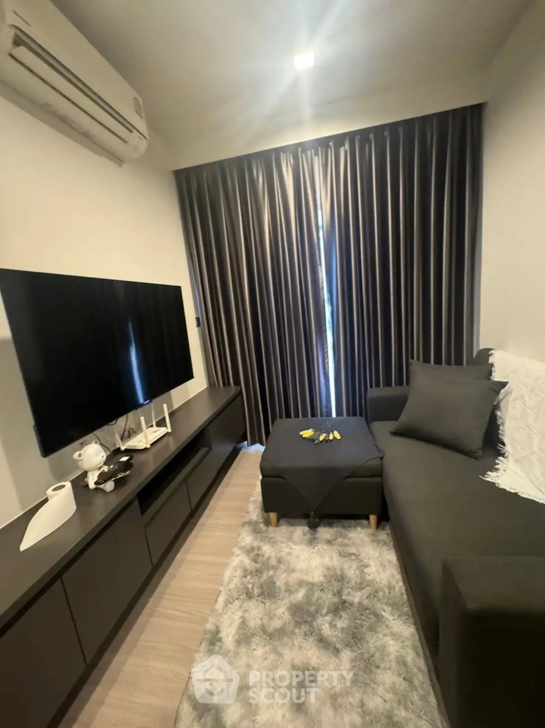 Modern living room with sleek furniture and large TV, perfect for relaxation.