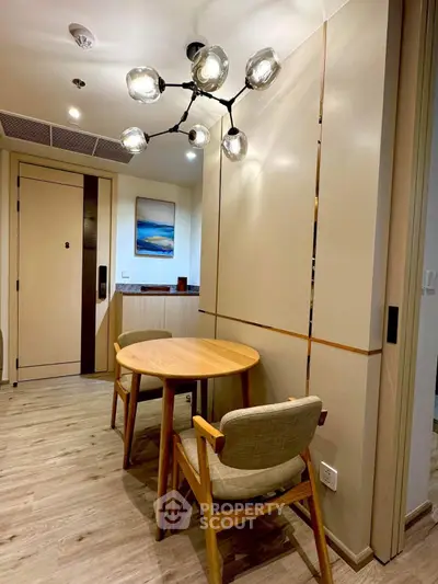 Modern dining area with stylish lighting and wooden furniture in a cozy apartment.