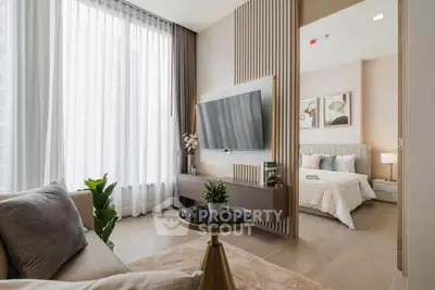 Modern living room with elegant decor and view into cozy bedroom