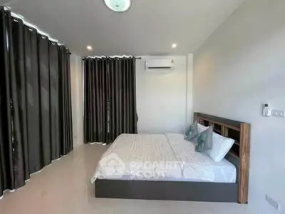 Spacious modern bedroom with elegant curtains and air conditioning