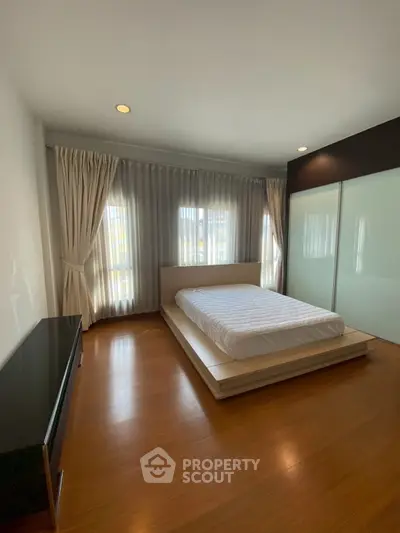 Spacious bedroom with modern design and large windows for natural light.