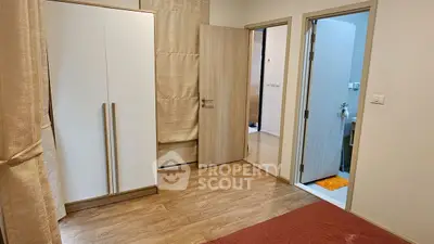 Spacious bedroom with wooden flooring and modern wardrobe