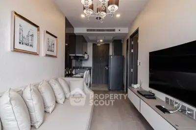 Modern living room with sleek decor and open kitchen layout in a stylish apartment.
