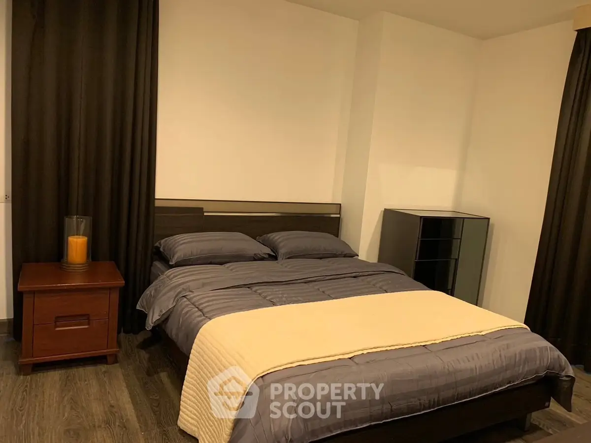 Cozy bedroom with modern decor and dark curtains, perfect for restful nights.