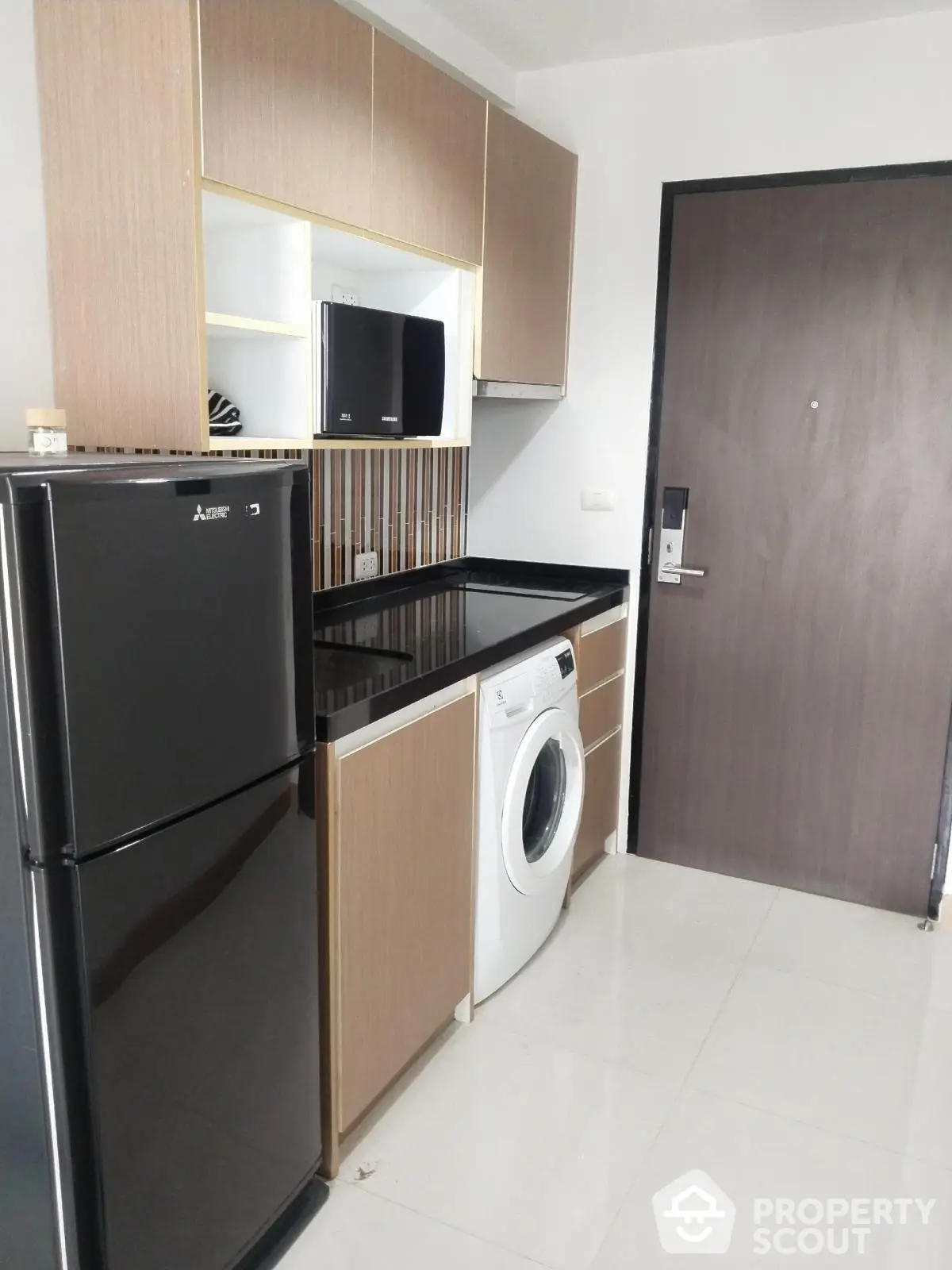 Modern kitchen with sleek appliances and stylish cabinetry in a compact layout.