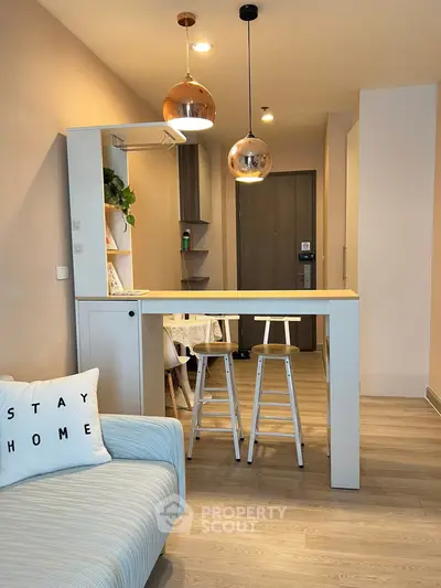 Modern open-plan living area with stylish lighting and cozy seating.