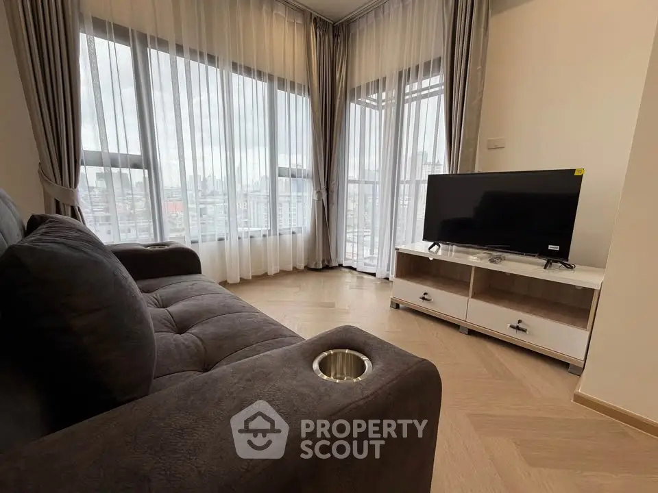 Modern living room with cozy sofa and city view through large windows