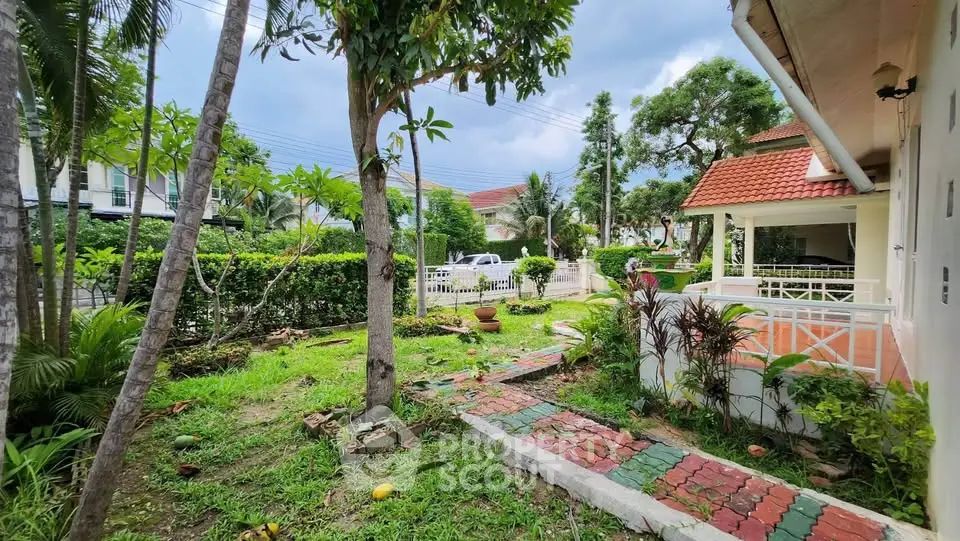 Charming garden view of suburban home with lush greenery and inviting pathway.